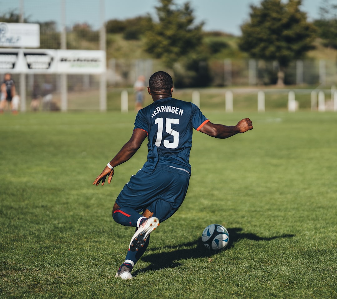 Football player wearing a blue and white match kit on the pitch